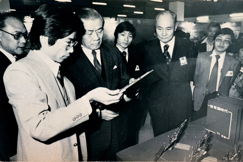 1980年代，杜書伍（左二）在資訊週推廣微處理器，為時任資政孫運璿（左三）進行解說。（照片由聯強國際集團提供）