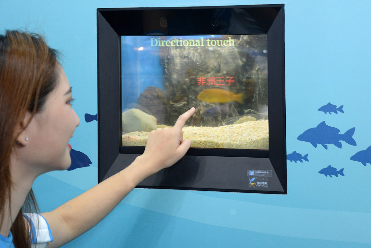 「動態虛實互動水族窗」結合全球最高穿透率的「高透明AMOLED觸控顯示器」、「動態物件辨識」與「指向互動技術」，只需朝目標點一下，該項魚種的資訊顯示在透明的魚缸上。